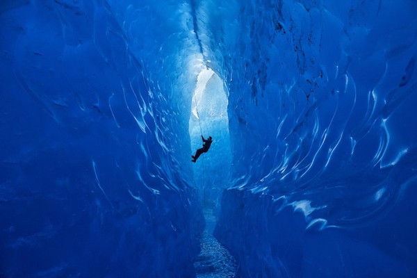 Climber Rappelling Into Cave